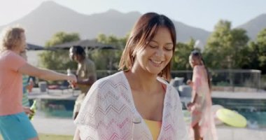 Farklı arkadaşlarla havuz partisinde güneşin altında dans eden mutlu çift ırklı kadın portresi, yavaş çekim. Yaz, yaşam tarzı, arkadaşlık, kutlama ve parti, değişmeden.