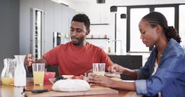 Afro-Amerikan çifti mutfakta kahvaltı servisi ve yemek yapıyor, ağır çekimde. Yaşam tarzı, birliktelik, yemek, yemek ve ev hayatı, değişmemiş..