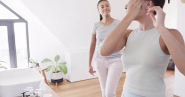 Mutlu çift ırklı lezbiyen çift sabahları güneşli banyoda sarılıp gülümsüyor, ağır çekimde. Yaşam tarzı, ilişki, birliktelik, aşk, mutluluk ve ev hayatı, değişmemiş..