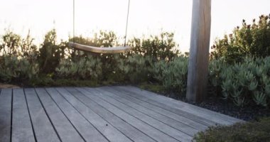 Gün batımında sükunet bahçesinde yavaşça sallan. Yaşam tarzı, doğa, rahatlama ve boş zaman..