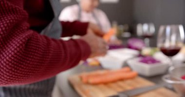 Üst düzey melez çift mutfakta sebze soyuyorlar, değiştirilmeden, ağır çekimde. Kıdemli yaşam tarzı, aşçılık ve ev hayatı..