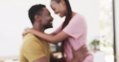Mutlu Afro-Amerikan çiftler oturma odasında gülümsüyor ve kucaklaşıyorlar, ağır çekimde. Yaşam tarzı, ilişki, birliktelik, aşk ve aile hayatı, değişmemiş..