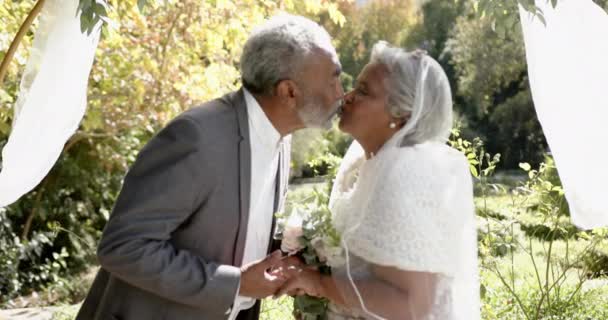 Casal Biracial Sênior Feliz Abraçando Sorrindo Durante Cerimônia Casamento Jardim — Vídeo de Stock
