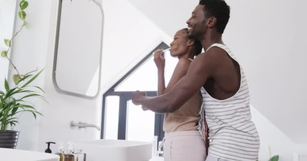 幸せなアフリカ系アメリカ人のカップルの歯をブラッシングし バスルームで抱擁 スローモーション ライフスタイル セルフケア 愛と国内生活 変わらない — ストック動画