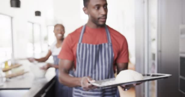 Felice Coppia Afro Americana Grembiuli Cuocere Pane Mettendo Pasta Forno — Video Stock