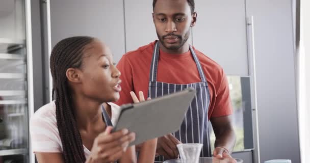 Afro Amerikan Önlüklü Mutlu Çift Mutfakta Tablet Kullanarak Yemek Pişiriyorlar — Stok video