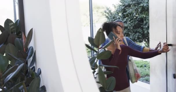 Feliz Casal Lésbico Biracial Chegando Casa Falando Smartphone Câmera Lenta — Vídeo de Stock