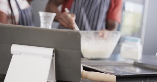 Afro Amerikan Önlüklü Mutlu Çift Mutfakta Tablet Kullanarak Yemek Pişiriyorlar — Stok video