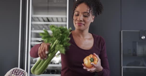 Melez Bir Kadın Alışveriş Torbalarını Bırakıyor Mutfakta Gülümsüyor Ağır Çekimde — Stok video
