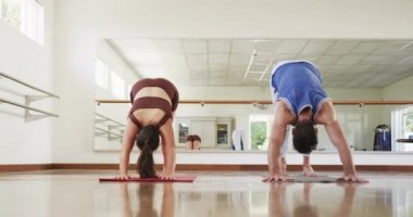 Kafkas erkek eğitmen ve kadın öğrenci jimnastik salonunda yoga yapıyor, ağır çekimde. Aktif yaşam tarzı, kobra pozu, eğitim, sağlık ve sağlık, değişmemiş.
