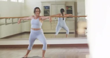 Kafkasyalı kadın spor salonunda yoga yapıyor, ağır çekimde. Aktif yaşam tarzı, yoga duruşu, eğitim, sağlık ve sağlık, değişmemiş.