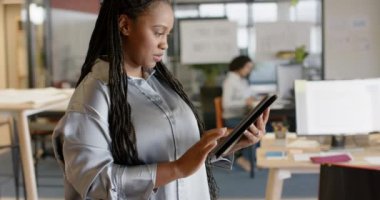 Ofiste gülümseyen tablet kullanan mutlu Afro-Amerikan iş kadını portresi, ağır çekimde. İş, güven, iletişim, ofis ve iş, değiştirilmemiş.