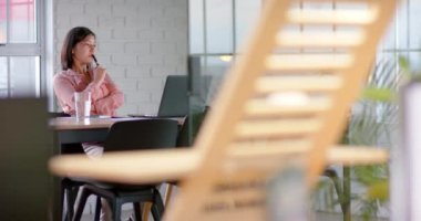 Asyalı mutlu iş kadını laptopunu kullanıyor ve notlar alıyor, toplantı odasında, ağır çekimde. İş, iletişim, ofis ve iş, değiştirilmemiş.