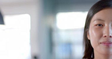 Ofisteki mutlu Asyalı kadının yarım portresi, ağır çekimde gülümsüyor, boşluğu kopyalıyor.. 