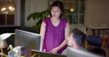 Masadaki çeşitli erkek ve kadın meslektaşlar geceleri ofiste bilgisayar kullanarak konuşuyorlardı. İş, iletişim, ofis, takım çalışması, teslim tarihi ve geç saatlere kadar çalışma, değiştirilmemiş.