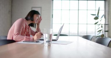 Laptop kullanan ve not alan Asyalı iş kadını toplantı odasında ağır çekimde. İş, iletişim, ofis ve iş, değiştirilmemiş.