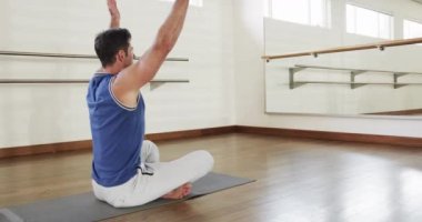 Odaklanmış beyaz adam spor salonunda yoga meditasyonu yapıyor, ağır çekimde. Aktif yaşam tarzı, yoga duruşu, eğitim, sağlık ve sağlık, değişmemiş.