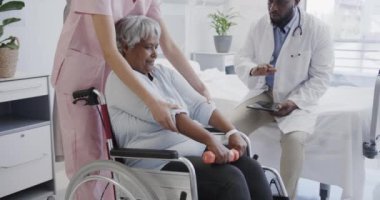 Birçok erkek doktor ve kadın fizyoterapist tekerlekli sandalyedeki yaşlı kadın hastayı yavaş çekimde tedavi ediyor. Sağlık hizmetleri, hastane, takım çalışması, fizyoterapi ve sağlık hizmetleri, değişmedi..