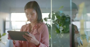 Ofiste tablet kullanan, ağır çekimde gülümseyen mutlu Asyalı iş kadını portresi. İş, iletişim, güven, ofis ve iş, değiştirilmemiş.