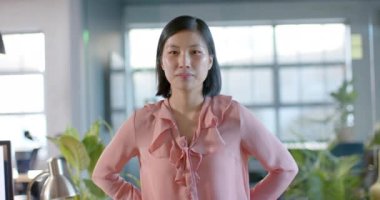 Ofisteki Asyalı mutlu iş kadınının portresi, ağır çekimde gülümsüyor. İş, güven, ofis ve iş, değiştirilmemiş.