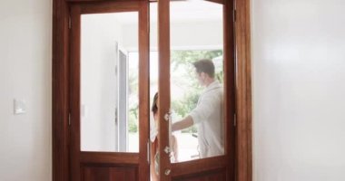 Market alışverişi yapan mutlu beyaz çift eve ağır çekimde geliyor. Yaşam tarzı, sağlık, refah ve ev hayatı, değişmedi..