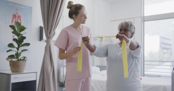 Fisioterapeuta Femenina Diversa Feliz Paciente Mayor Usando Bandas Ejercicio Cámara — Vídeos de Stock
