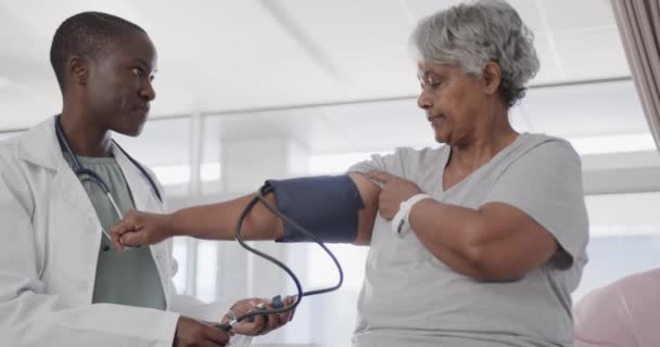 Щаслива Різноманітна Жінка Лікар Яка Приймає Кров Яний Тиск Старшого — стокове відео