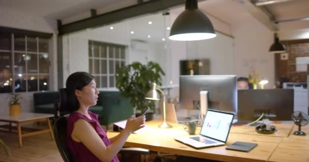 Счастливая Азиатская Деловая Женщина Использующая Ноутбук Разговаривающая Смартфоне Офисе Ночью — стоковое видео