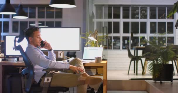 Уставший Двуличный Бизнесмен Столом Компьютерами Разговаривающий Телефону Офисе Ночью Замедленная — стоковое видео