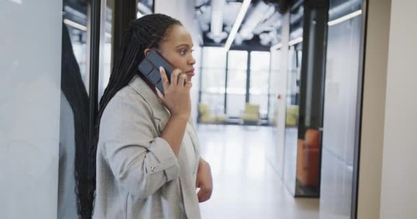 Endişeli Afrikalı Amerikalı Sıradan Kadını Ofis Koridorunda Akıllı Telefondan Konuşuyor — Stok video