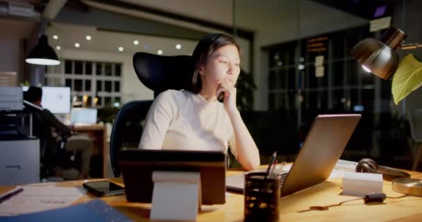 Сосредоточенная Азиатская Деловая Женщина Сидящая Столом Используя Ноутбук Офисе Ночью — стоковое видео