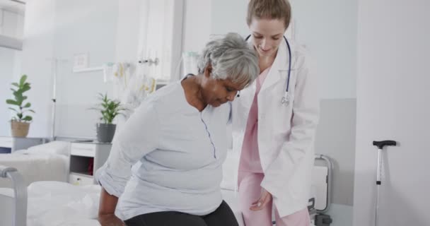 Glad Varierad Kvinnlig Läkare Hjälpa Äldre Kvinnliga Patienten Stå Från — Stockvideo
