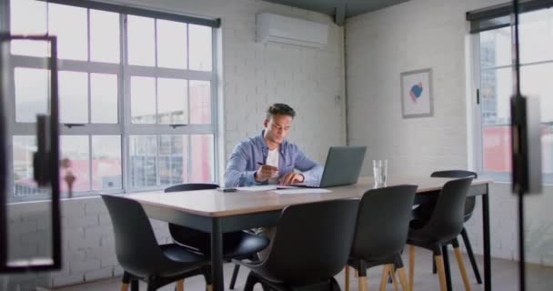 Сосредоточенный Двуличный Бизнесмен Использующий Ноутбук Делающий Заметки Столом Конференц Зале — стоковое видео