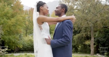 Mutlu Afrikalı Amerikalı gelin ve damat bahçede dans ediyor, ağır çekimde. Yaz, düğün, evlilik, romantizm, gelenek ve kutlama, değiştirilmemiş.