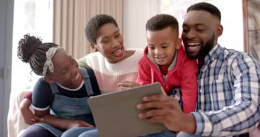 Mutlu Afro-Amerikan ebeveynler, oğlu ve kızı evde selfie çekiyorlar, ağır çekimde. Aile, iletişim, ebeveynlik, çocukluk, yaşam tarzı, bakım ve aile hayatı, değiştirilmemiş.