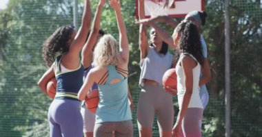 Mutlu çeşitli bayan basketbol takımları yavaş çekimde güneşli sahada antrenman yapıyor. Spor, fitness, sağlık ve açık hava aktiviteleri, değiştirilmemiş.