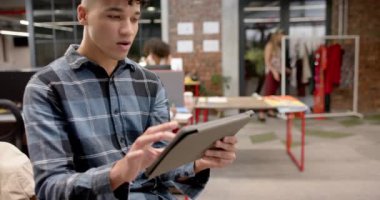 Moda stüdyosunda ağır çekimde duran mutlu çift ırklı erkek tasarımcının portresi. Günlük ofis, iş, tasarım ve yaratıcı çalışma.