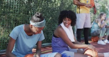 Güneşli sahada erkek koçla ağır çekimde çeşitli bayan basketbol takımları antrenmanınız kutlu olsun. Spor, fitness, sağlık ve açık hava aktiviteleri, değiştirilmemiş.