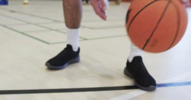 Beyaz erkek basketbol oyuncusu iç sahada ağır çekimde antrenman yapıyor. Spor, fitness, sağlık ve açık hava aktiviteleri, değiştirilmemiş.