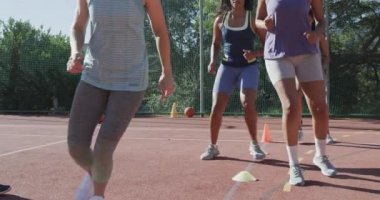 Güneşli sahada erkek koçla ağır çekimde çeşitli bayan basketbol takımları antrenmanınız kutlu olsun. Spor, fitness, sağlık ve açık hava aktiviteleri, değiştirilmemiş.