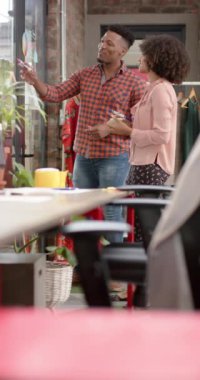 Ofiste ağır çekimde iş tartışan mutlu iş adamlarının dikey videosu. Küresel iş, takım çalışması ve çalışma.