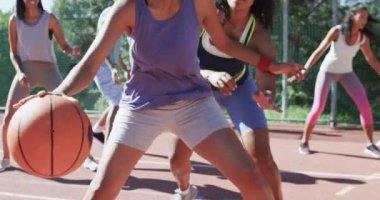 Güneşli sahada erkek koçla ağır çekimde çeşitli bayan basketbol takımları antrenmanınız kutlu olsun. Spor, fitness, sağlık ve açık hava aktiviteleri, değiştirilmemiş.