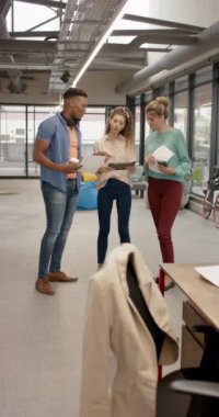 Yoğun iş adamlarının ofiste ağır çekimde iş tartışmalarının dikey videosu. Küresel iş, takım çalışması ve çalışma.