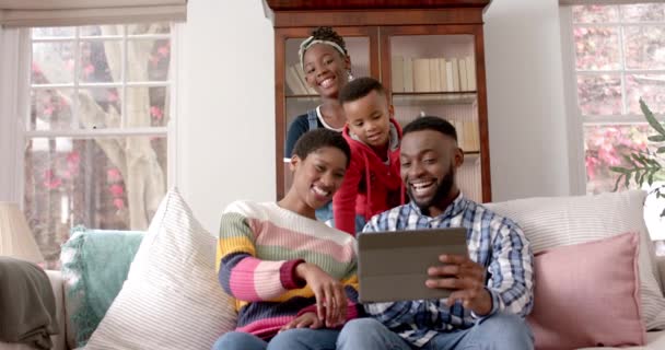 快乐的非洲裔美国父母 儿子和女儿坐在家里用平板电脑 动作缓慢 生活方式 照料和家庭生活 — 图库视频影像