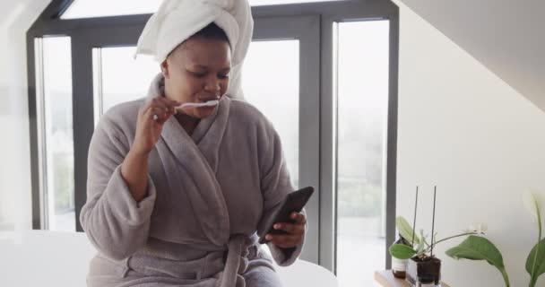 Afroamericano Size Donna Lavarsi Denti Utilizzando Smartphone Inalterato Rallentatore Stile — Video Stock