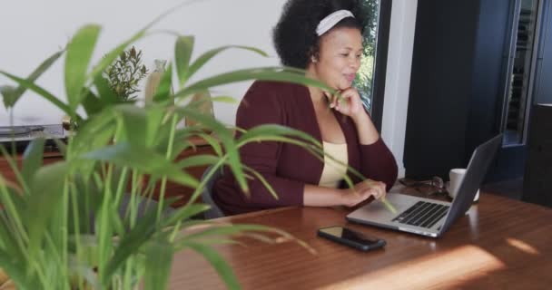 Африканский Американец Плюс Женщина Размера Сидящая Столом Использующая Ноутбук Неизменная — стоковое видео