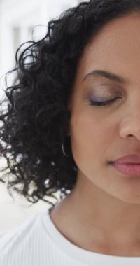 Evde yarı melez bir kadının yarı portresinin dikey videosu, ağır çekim. Aile, yaşam tarzı ve aile hayatı değişmedi..