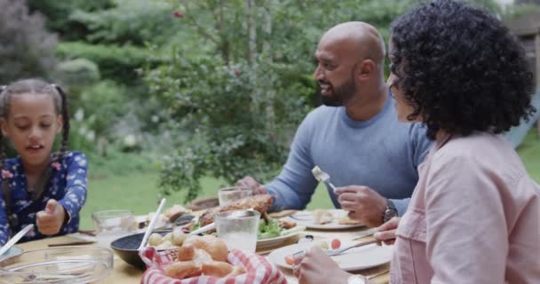 Pais Biraciais Felizes Filha Comendo Refeição Mesa Jantar Jardim Câmera — Vídeo de Stock