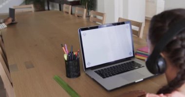 Çift ırklı kız, ekranda kopya alanı olan dizüstü bilgisayarı kullanarak internette öğreniyor. Ağır çekimde. Eğitim, iletişim, çevrimiçi öğrenme, çocukluk ve ev hayatı, değiştirilmemiş.