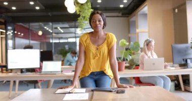 Ofiste gülümseyen, ağır çekimde mutlu bir Afrikalı Amerikalı iş kadınının portresi. İş, günlük ofis ve iş, değiştirilmemiş.